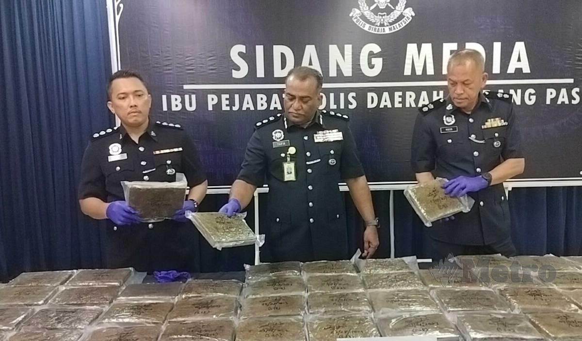 MOHD Taufik (tengah) menunjukkan sebahagian dadah jenis ganja mampat seberat 53 kg bernilai RM162,750 yang dirampas pada 3 Ogos lalu. FOTO Zuliaty Zulkiffli