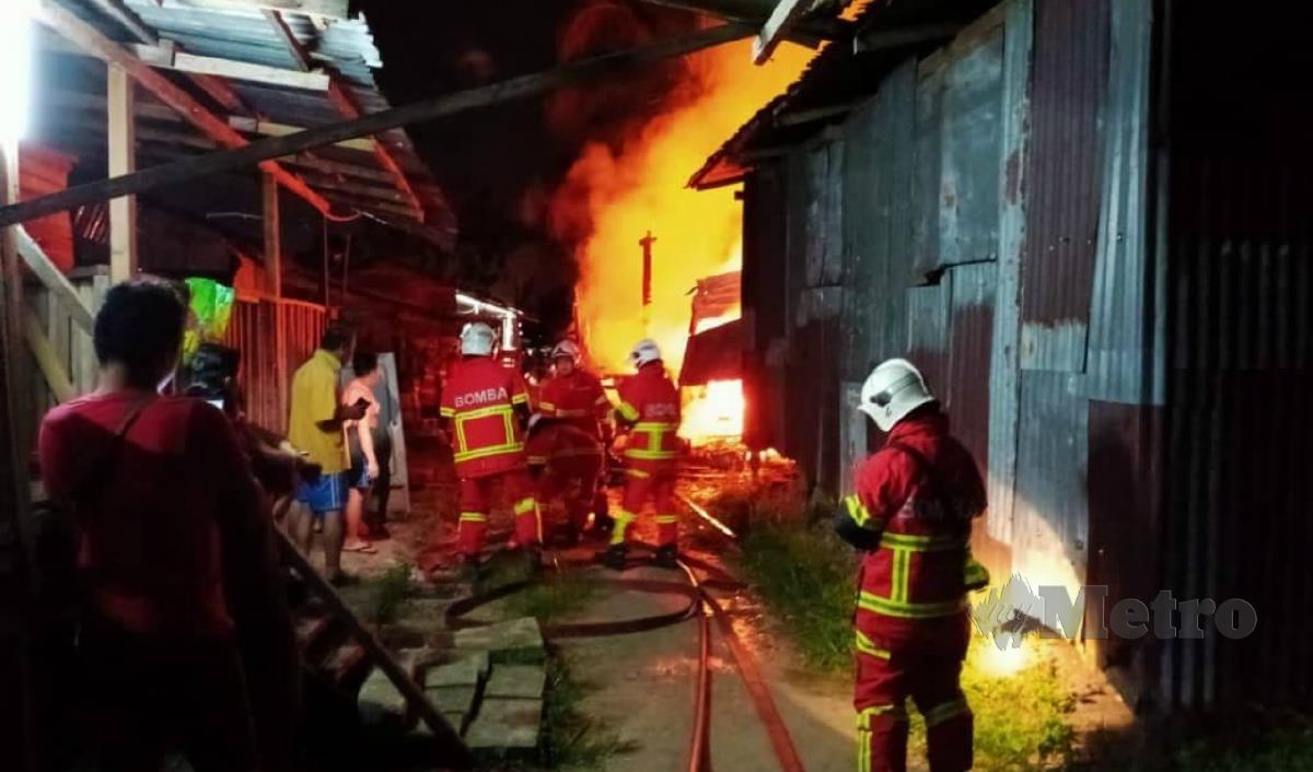 ANGGOTA bomba berusaha memadam kebakaran rumah setinggan di Kampung Sungai Plan, Jalan Pesisir Pantai Bintulu-Miri, malam tadi. FOTO ERIKA GEORGE