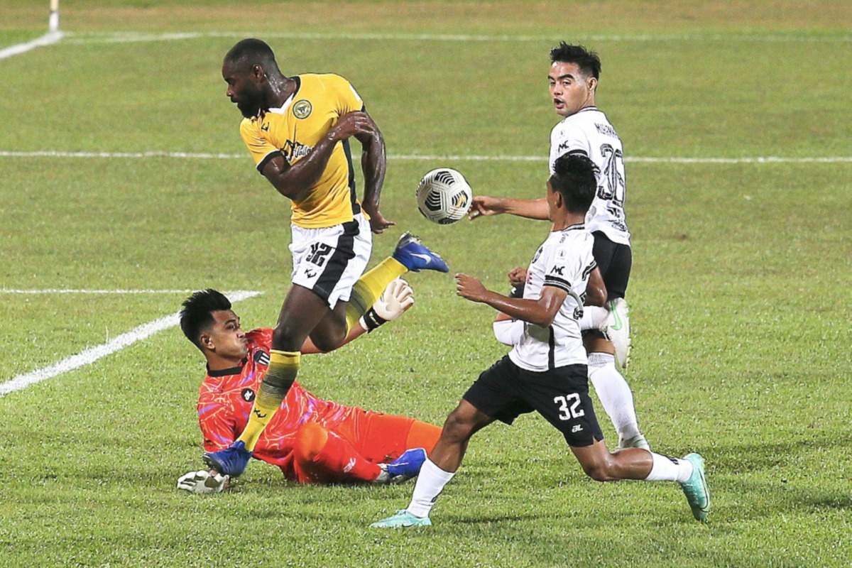 Pemain Perak FC II Ghislain Guessan (dua kiri) menendang bola namun berjaya diselamatkan oleh penjaga gol TFC II dalam aksi Liga Perdana. FOTO Ghazali Kori