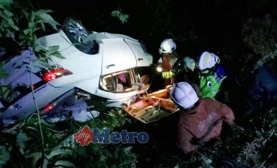 ANGGOTA bomba berusaha mengeluarkan mangsa tersepit di dalam kereta yang terbabas ke dalam gaung di Kilometer 19, Jalan Kuala Lumpur-Ipoh menghala ke Rawang berhampiran Hutan Rimba Templer di Gombak, awal pagi hari ini. FOTO ihsan bomba.