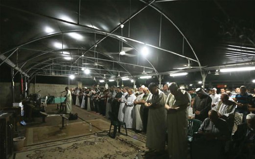 PENDUDUK Gaza menunaikan solat Tarawih di dalam khemah.