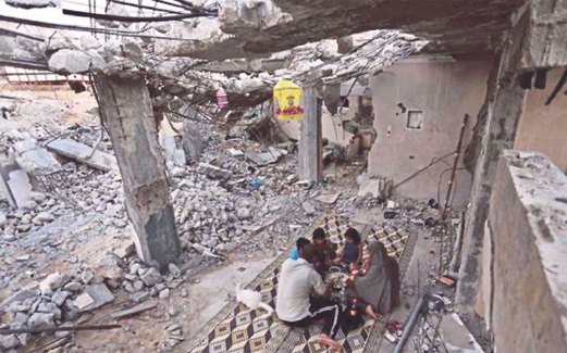 KELUARGA Saleh  berbuka puasa di celah runtuhan rumah mereka.