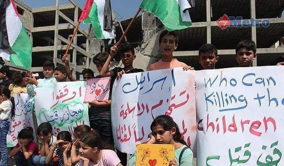 KANAK-KANAK Palestin berkumpul di hadapan bangunan Katibah berhampiran pusat bandar Gaza untuk menyatakan bantahan terhadap serangan Israel yang meragut nyawa dua rakan mereka. FOTO NSTP