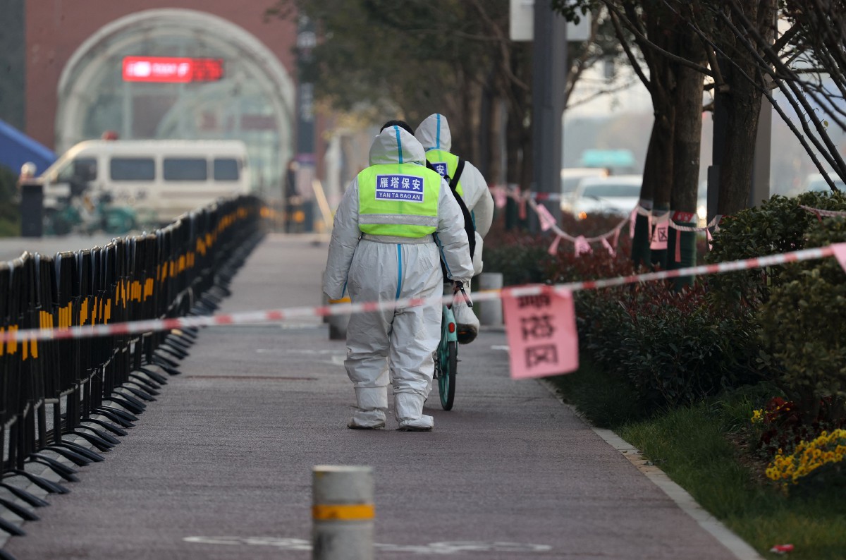 PETUGAS keselamatan berjalan di bandar Xi’an yang dikenakan perintah berkurung. FOTO AFP.