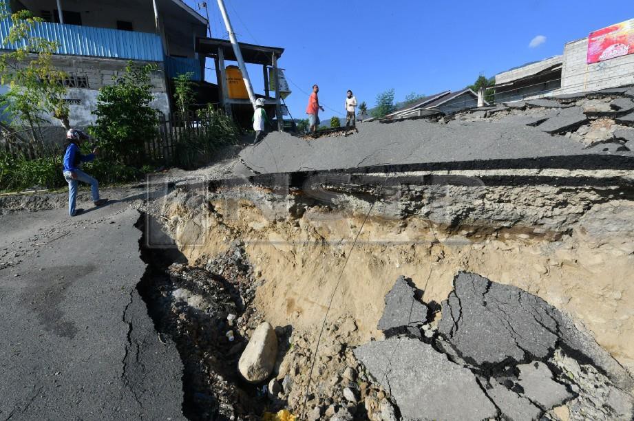 KEADAAN jalanraya yang rosak teruk menghalang bantuan daripada tiba di kawasan Balaroa, Palu. -Foto AFP