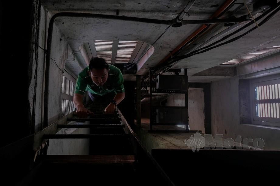 MOHD Suhaimi menaiki dua tingkat tangga dengan berketinggian 50 kaki untuk melakukan pemeriksaan jam. FOTO BERNAMA