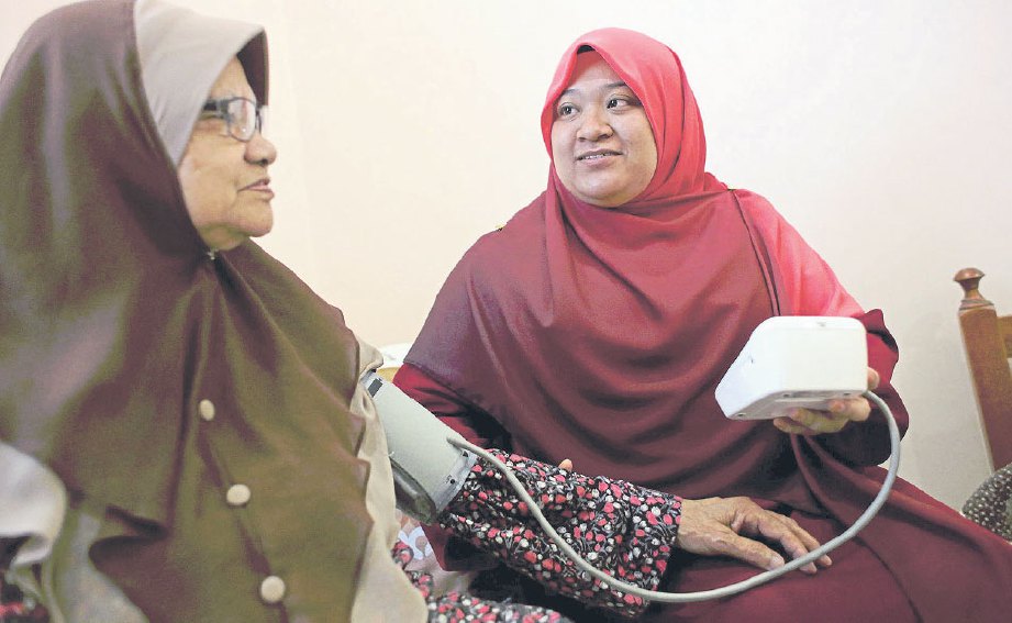 NURUL AZLIZA mengambil tekanan darah penghuni Darul Insyirah, Normah Mohd.