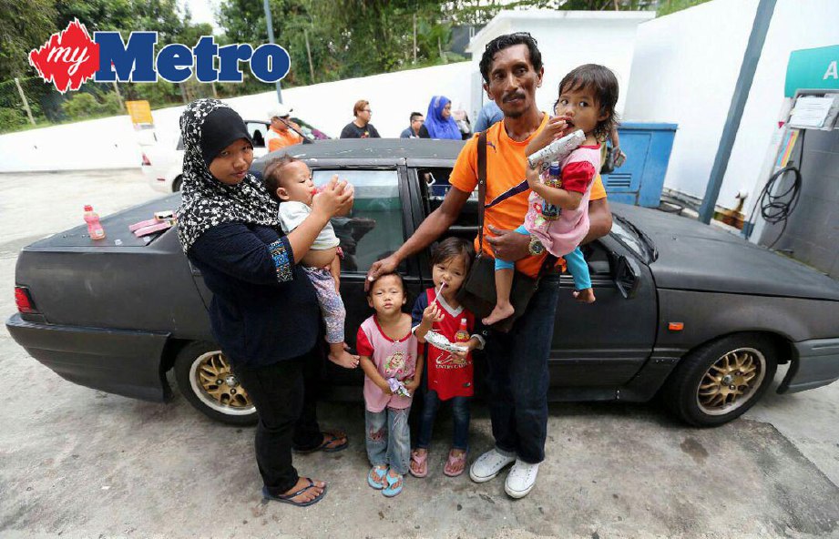 MOHD Sani (kanan) dan isteri (kiri), bersama empat daripada tujuh anak mereka ketika ditemui di Stesen Minyak Petronas Kempas Baru, hari ini. FOTO Mohd Azren Jamaludin
