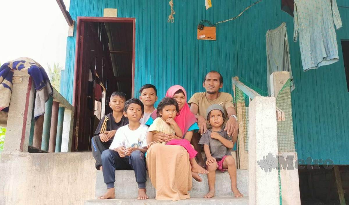 MOHD Asrul dan isteri, Rozila bersama lima anak mereka yang hidup bergelap lebih 10 tahun lalu sebelum berkongsi bekalan elektrik menerusi rumah sepupu mereka disebabkan tidak mampu membayar tunggakan bil elektrik berjumlah RM2,300 ketika ditemui di rumahnya di Kampung Pangkal Ketereh. FOTO Siti Rohana Idris
