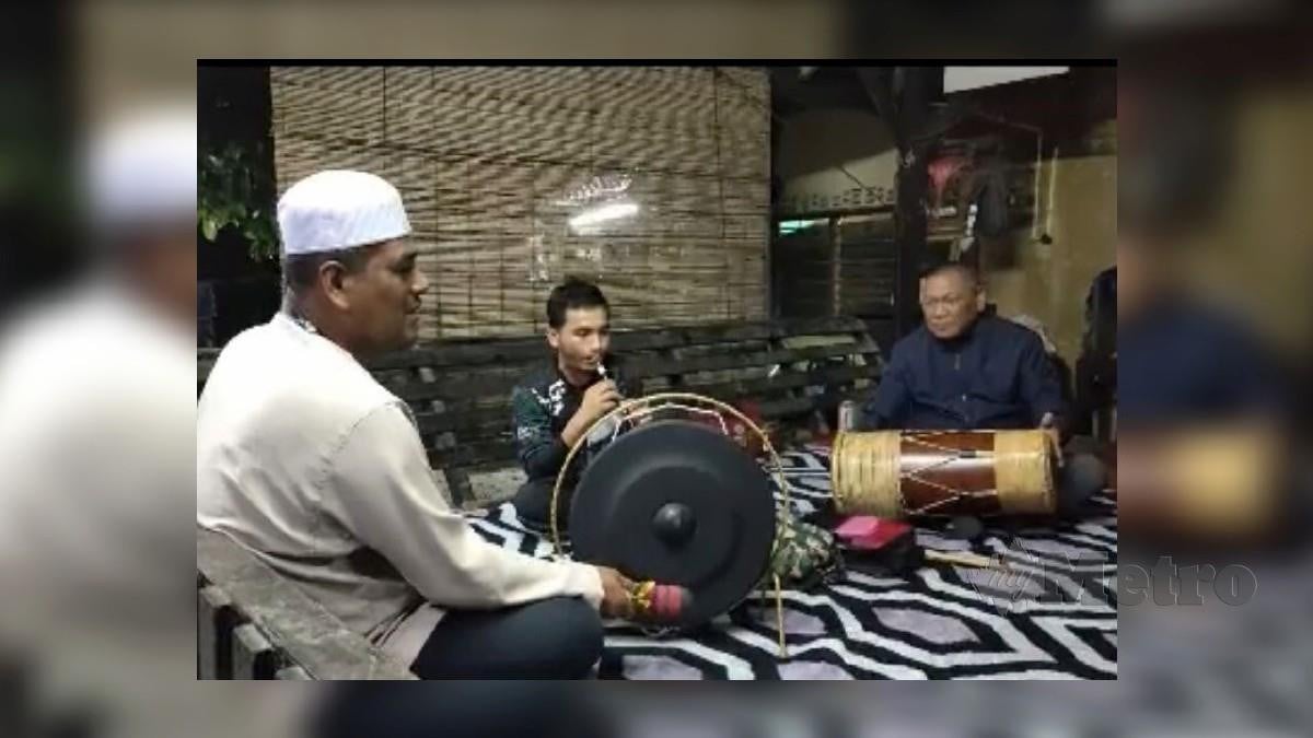 MOHD Nizar (kanan) bersama Khairul Shahril (kiri) menunjukkan kebolehan bermain alat muzik tradisional.