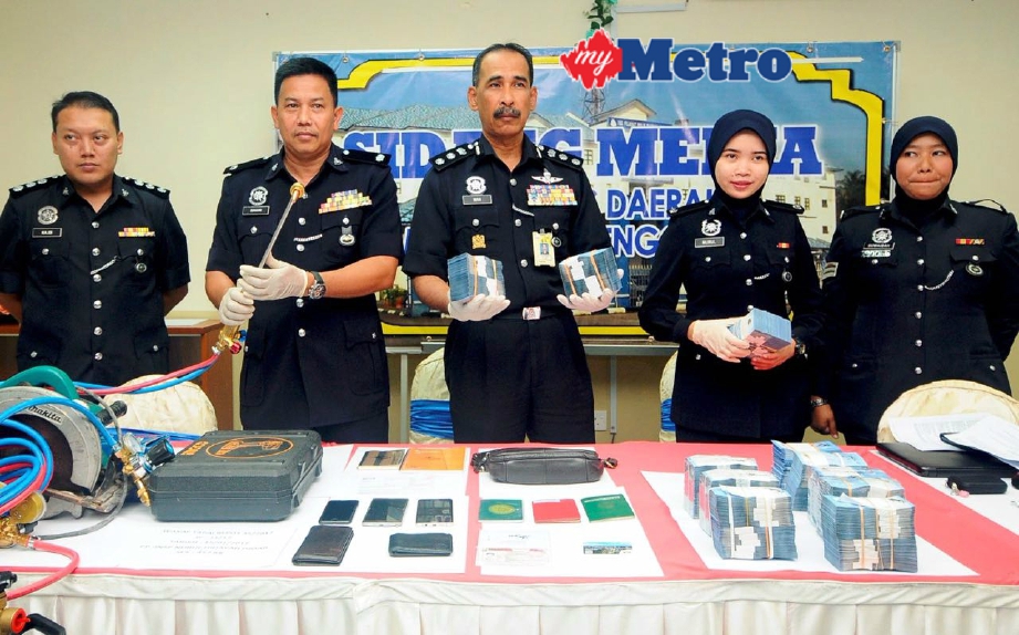 Wan Abd Aziz (tengah) dan Ketua Polis Daerah Marang Deputi Superintendan Mohd Suhaimi Ali (dua, kiri) menunjukkan barangan yang dirampas daripada Geng Tebuk pada sidang media di IPD Marang. FOTO Mohd Syafiq Ridzuan Ambak 