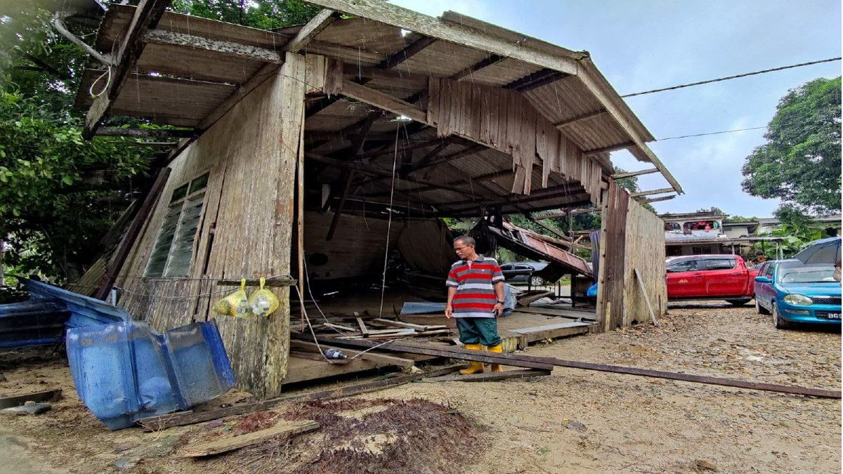 AZLAN memeriksa keadaan rumahnya yang bergerak 30 meter dibawa arus deras di Kampung La, di Besut, hari ini. FOTO Nurul Fatihah Sulaini.