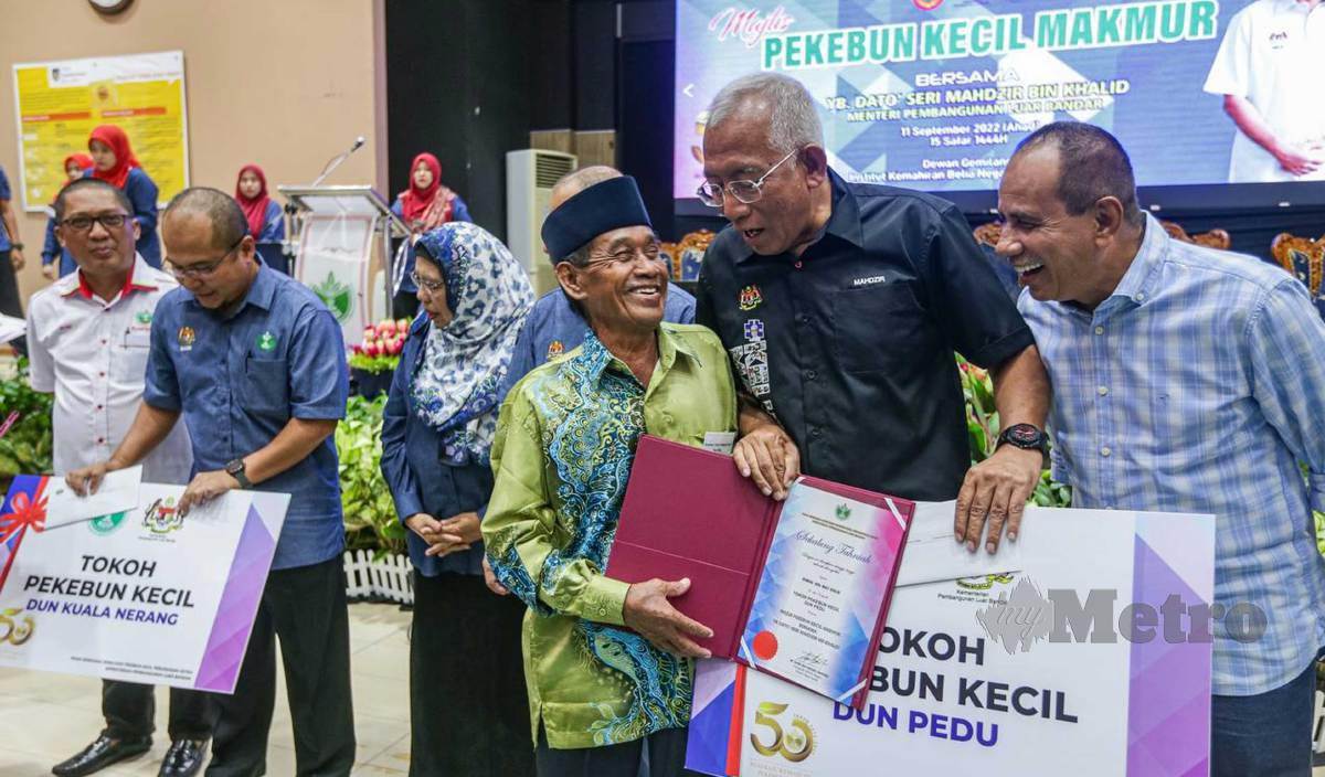 MAHDZIR Khalid (dua kanan) menyampaikan anugerah Tokoh Pekebun Kecil RISDA Pedu kepada Ismail Mat Daud (tiga kanan) pada Majlis Pekebun Kecil Makmur di IKBN Naka, Kuala Nerang. FOTO Luqman Hakim Zubir
