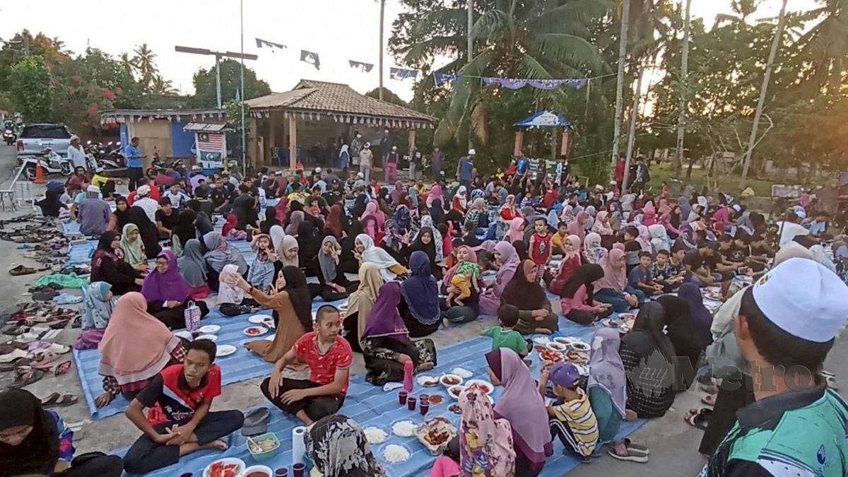 Penduduk Kampung Teluk Paku berkumpul untuk berbuka puasa pada Majlis Berbuka Puasa Sekampung di dataran kampung berkenaan. FOTO ZAID SALIM