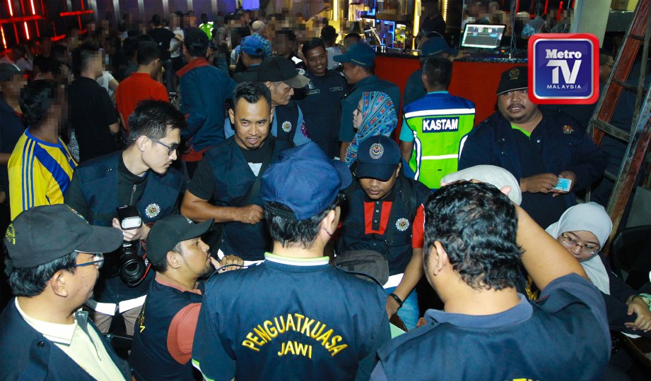 PIHAK berkuasa memeriksa kad pengenalan pengunjung pusat hiburan di Jalan Sultan Ismail, semalam. FOTO Asyraf Hamzah