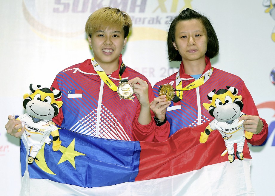 Anna (kanan) dan Ee Wei memenangi pingat emas dalam acara badminton akhir beregu wanita di Arena Badminton Ipoh. -Foto L MANIMARAN