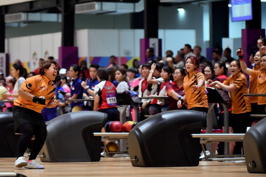 SHALIN (kiri) meraikan kejayaan bersama rakan sepasukan selepas menjatuhkan kesemua pin dalam acara boling berpasukan enam wanita pada Sukan Asia Jakarta-Palembang 2018 di Komplex Sukan Bowling Jakabaring. -Foto BERNAMA