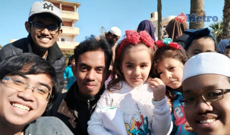 GHAFUR  (tiga dari kiri) bersama pelajar  universiti Mesir  pada  program kemasyarakatan bersama kanak-kanak negara    berkenaan.  FOTO NSTP