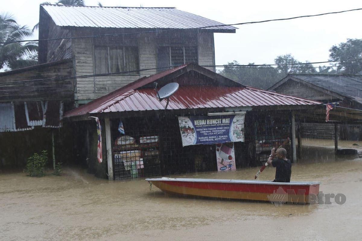 HARUN Ismail, 64, menaiki sampan melihat keadaan kedai runcitnya yang ditenggelami air sedalam 1.5 meter susulan hujan berterusan sejak petang semalam di Kampung Padang Kubu. FOTO Ghazali Kori