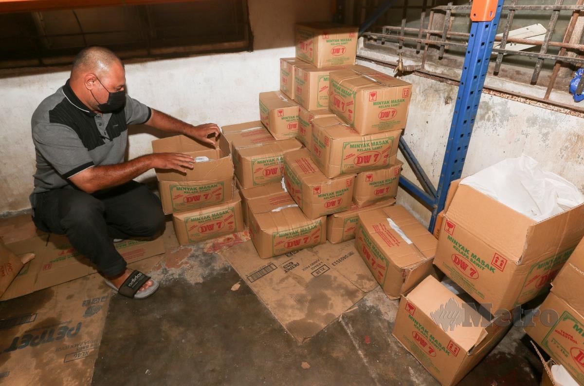 Salah seorang pekerja kedai runcit memeriksa bekalan minyak masak untuk dijual kepada pelanggannya ketika tinjauan di sebuah kedai runcit di sekitar Rantau Panjang. FOTO NIK ABDULLAH NIK OMAR