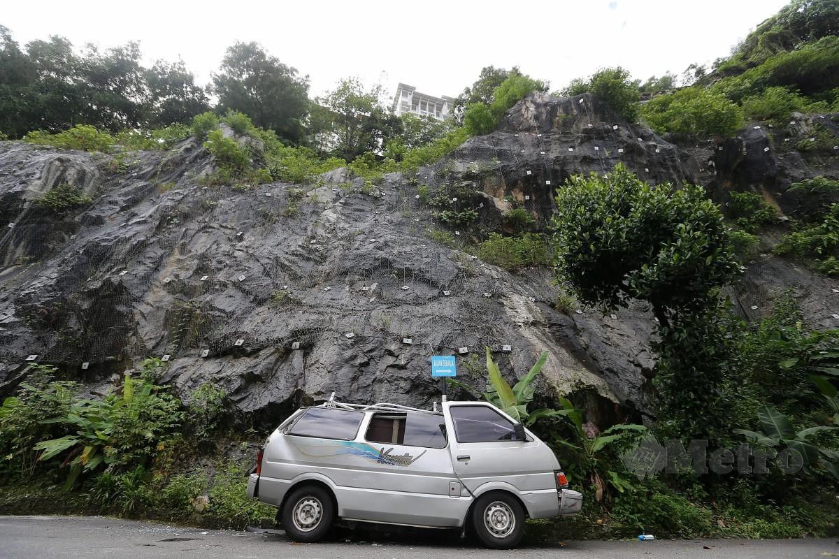 Keadaan Kereta yang rosak teruk akibat dihempap batu yang jatuh daripada bukit berhampiran di Pangsapuri Intan Taman Bukit Permai. FOTO SAIFULLIZAN TAMADI