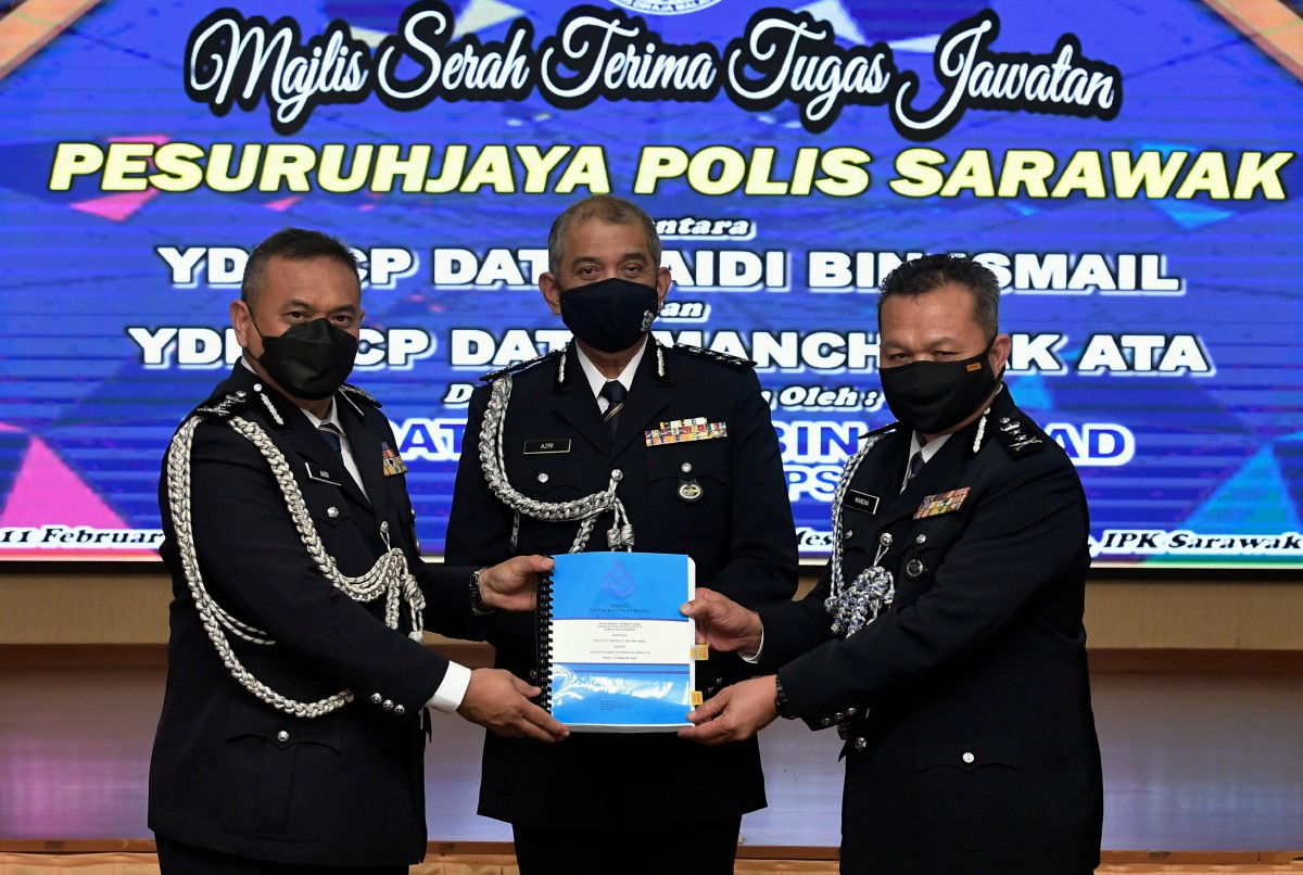 Azri Ahmad menyaksikan Aidi Ismail (kiri) menyerahkan Nota Serah Tugas kepada Mancha Ata pada Majlis Serah Terima Tugas di Ibu Pejabat Polis Kontinjen Sarawak (IPK) hari ini. FOTO BERNAMA