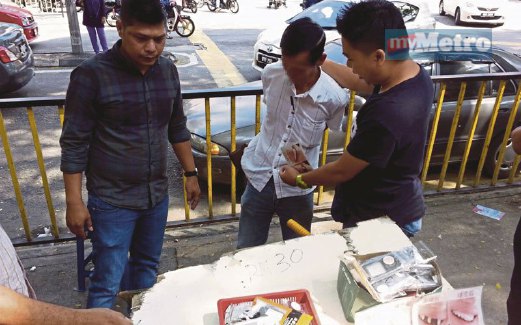PEGAWAI dari KKM menahan doktor palsu di Jalan Pasar.