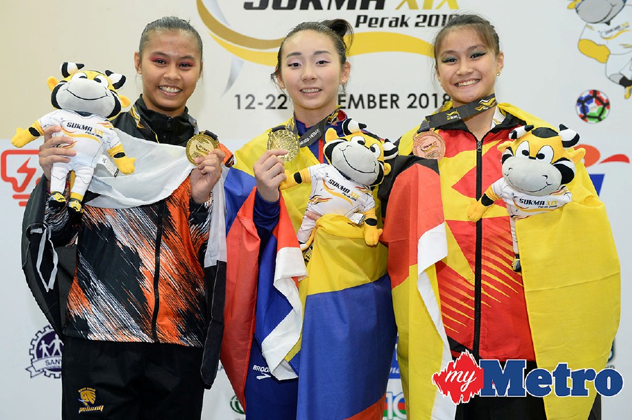NUR Bahirah (kiri) dan Greanie berkongsi pingat emas acara gimnastik wanita keseluruhan. -Foto SUKMA 2018