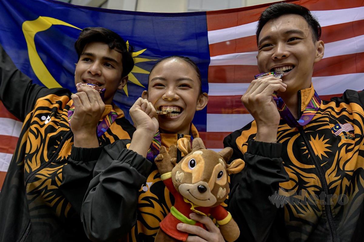 RACHEL bergambar bersama pingat emas yang berjaya diraihnya dalam acara Palang Bertingkat, Tan Fu Jie dan Muhammad Sharul Aimy. -FOTO Bernama