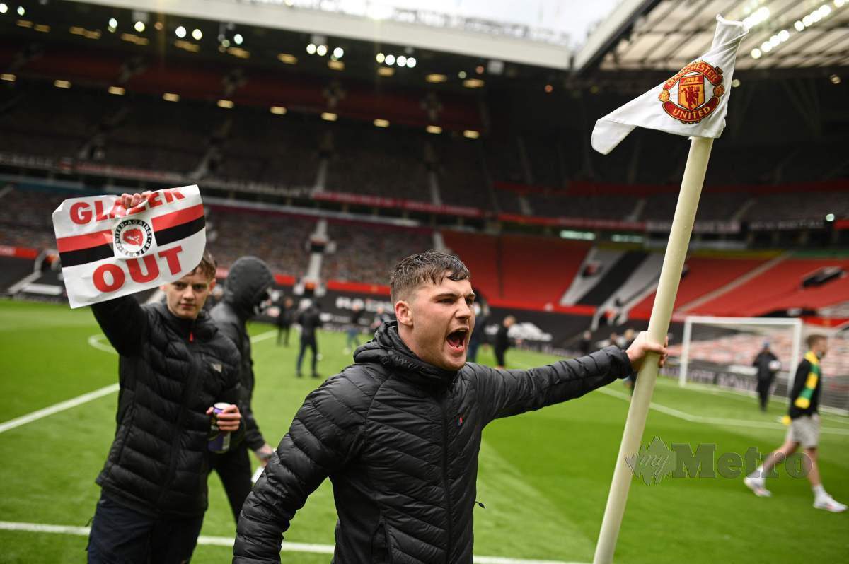 PENYOKONG United menceroboh masuk di dalam padang Old Trafford. FOTO AFP