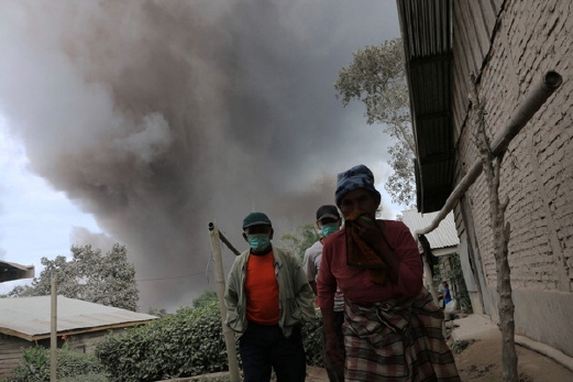 Penduduk Kampung Sukandebi, Karo, Sumatera Utara, meninggalkan rumah mereka yang diselubungi debu panas Gunung Berapi Sinabung. - Foto ANTARA/REUTERS