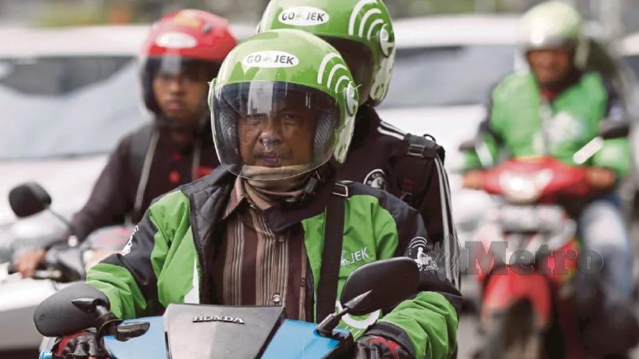 Penunggang Go-Jek membawa penumpangnya di Jakarta, Indonesia 