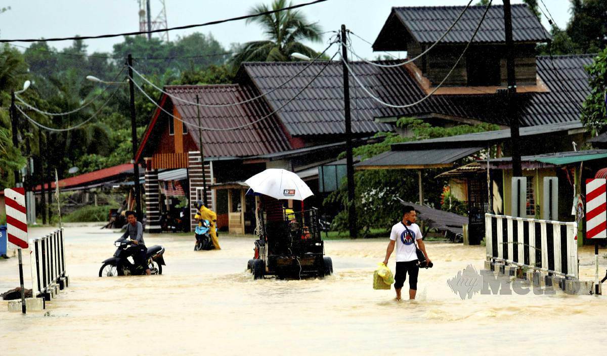 PENDUDUK meredah banjir di Kampung Gong Terap. FOTO Ghazali Kori