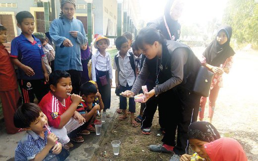 SISWA UPSI menunjukkan cara betul menjaga kebersihan gigi kepada kanak-kanak di Kampung Pray Bis, Kemboja.