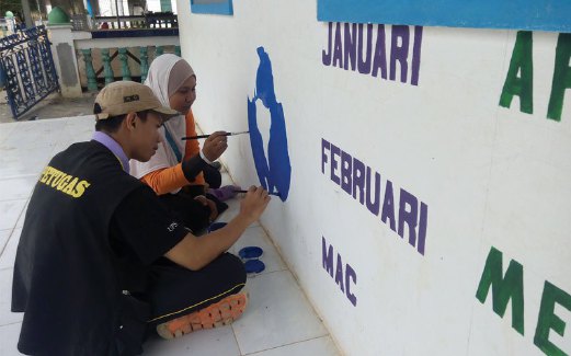 DUA sukarelawan menyiapkan mural di bangunan sekolah.