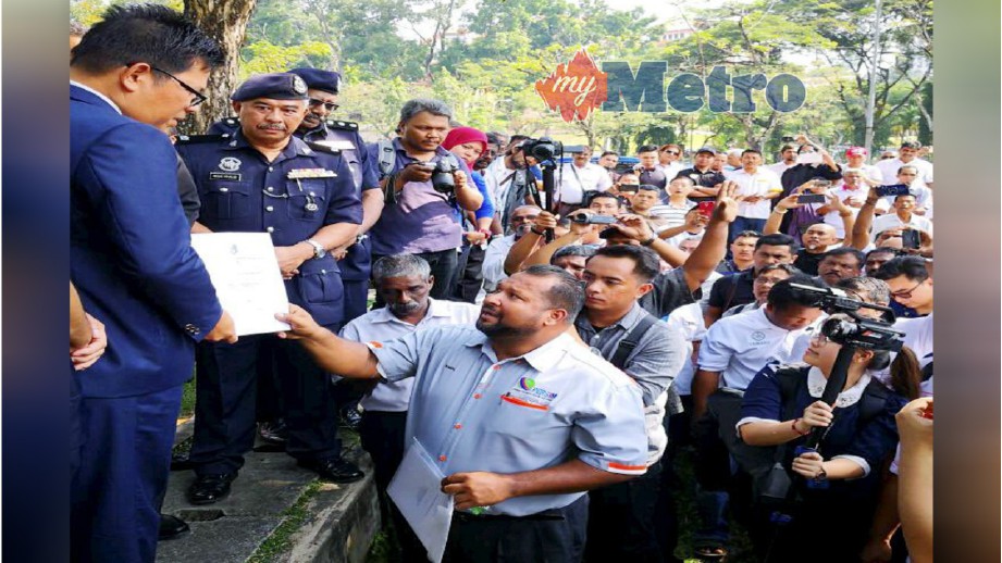 WAKIL pemandu teksi menyerahkan memorandum bantahan kepada Dahlan (kiri), hari ini. FOTO Ihsan TV3