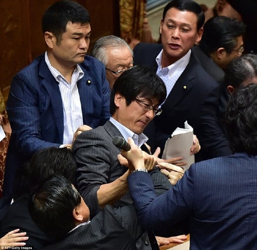 Seorang Ahli Parlimen pembangkan cuba merampas pembesar suara daripada Speaker Yoshitada Konoike (tidak kelihatan). - Foto  AFP