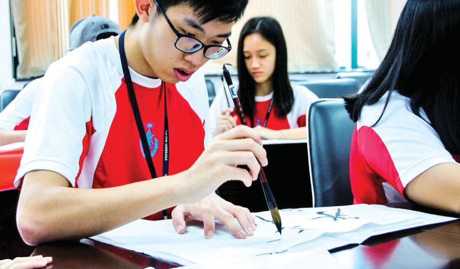 KELIHATAN peserta tekun mempelajari kaligrafi Cina.