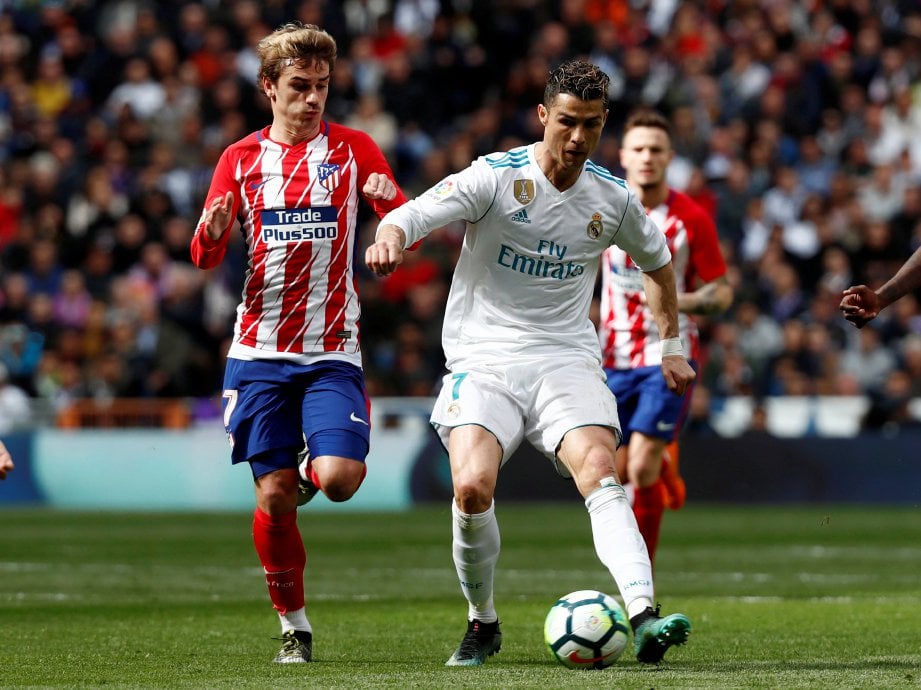 PEMAIN Real, Cristiano Ronaldo bersaing dengan penyerang Atletico, Antoine Griezmann pada aksi liga di Santiago Bernabeu. - Foto REUTERS