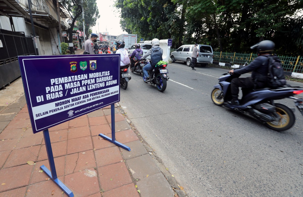 Pasukan keselamatan memeriksa kenderaan melalui Jalan Lenteng Agung di Jakarta susulan PPKM Darurat. FOTO EPA.