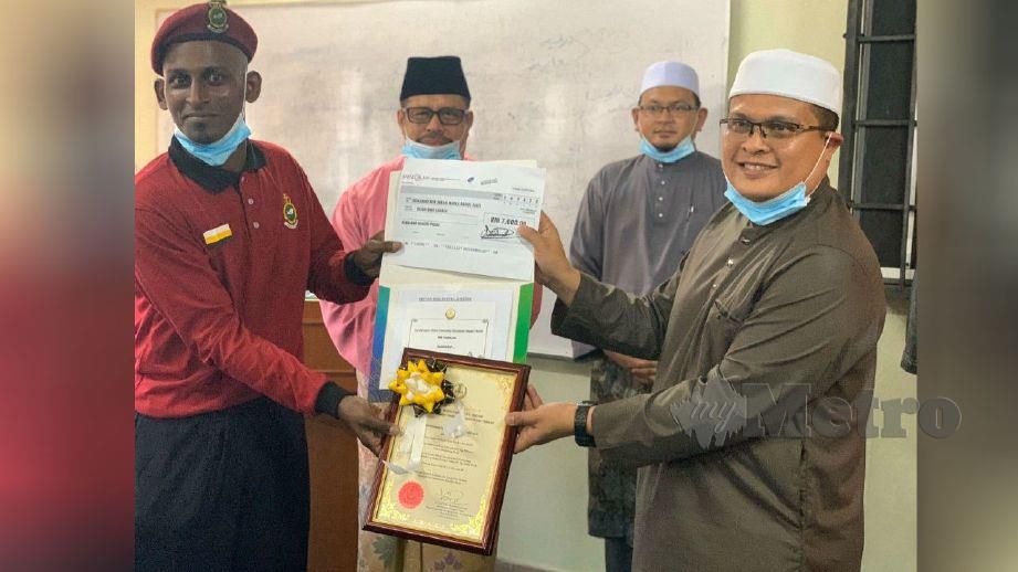 MUHAMMAD Nor Imran (kiri) menerima sumbangan dan penghargaan daripada kerajaan negeri yang disampaikan Mohd Akmal. FOTO Noor Hidayah Tanzizi 