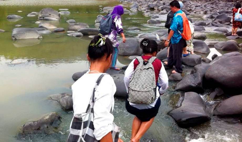 MURID dan guru SK Pangi melalui sungai untuk ke sekolah.