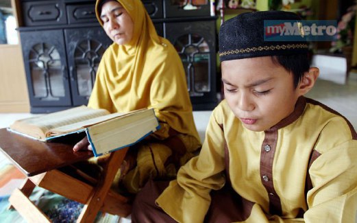 HAIKAL menghafal ayat al-Quran sambil disemak oleh neneknya Asmah Yusof . FOTO Zulkarnain Ahmad Tajuddin
