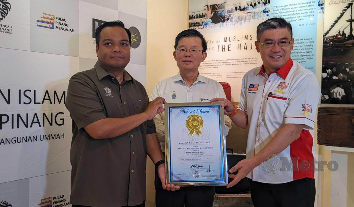 HONG Wai (kanan) melakukan simbolik penyerahan sijil pengiktirafan Galeri Haji Pulau Pinang sebagai Galeri Haji Pertama di Malaysia kepada Mohd Fitri (kiri) sambil disaksikan Kon Yeow. FOTO Zuhainy Zulkiffli