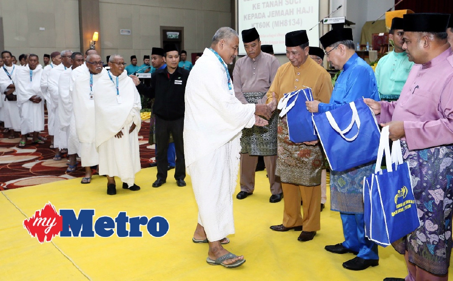 Tunku Sallehuddin menyampaikan  cenderahati kepada bakal haji sambil disaksikan oleh Ahmad Bashah (dua dari kanan) dan Pengerusi Tabung Haji Datuk Seri Abdul Azeez Abdul Rahim (kanan). FOTO Amran Hamid