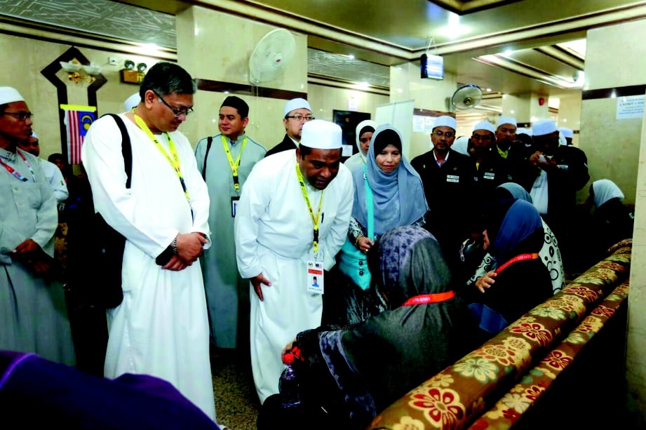  Abdul Azeez  (hadapan, dua dari kiri) bertemu  balu  jemaah yang meninggal dunia. 