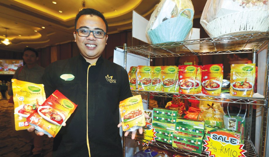 USAHAWAN dari Melaka Shahrom Mohd Salleh bersama pes makanan keluaran syarikatnya, Nyiru Food Industries Sdn Bhd.