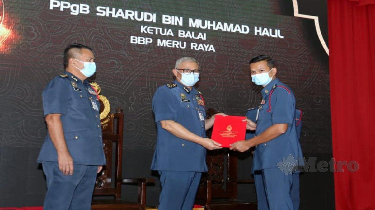 MOHAMAD Hamdan (dua kiri) menyampaikan Anugerah Perkhidmatan Cemerlang kepada Ketua Balai Bomba Meru Raya Penolong Penguasa Bomba, Sharudi Muhammad Halil (kanan) sambil diperhatikan Azmi hari ini. FOTO L.MANIMARAN