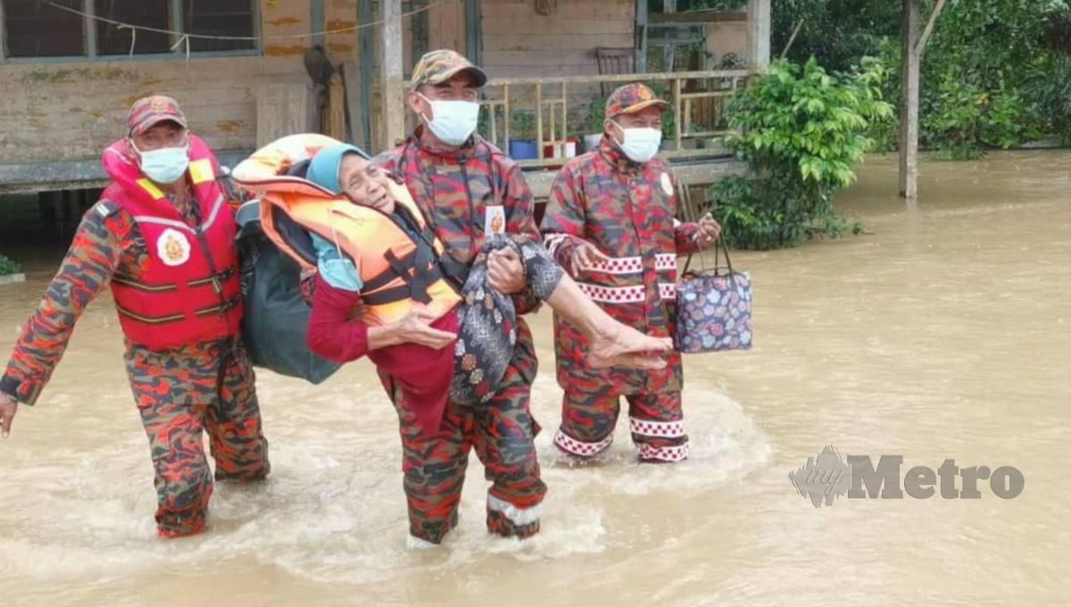BOMBA membantu memindahkan Hamidah Long yang menjadi antara mangsa banjir dari Kampung Hilir, Pasir Gajah yang dipindahkan ke pusat pemindahan sementara di PPS Pasir Gajah. FOTO ZATUL IFFAH ZOLKIPLY