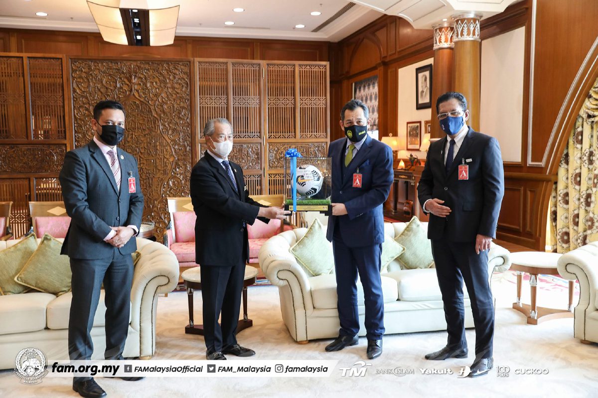 HAMIDIN (dua kanan) menyampaikan cenderahati kepada Perdana Menteri. FOTO FB FAM